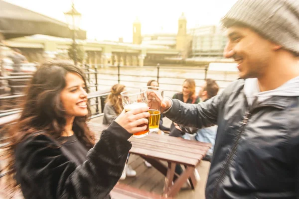 Happy friends couple drinking beer and toasting — Stock Photo, Image