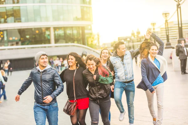 Multirasistiska grupp vänner att ha kul i staden vid solnedgången — Stockfoto