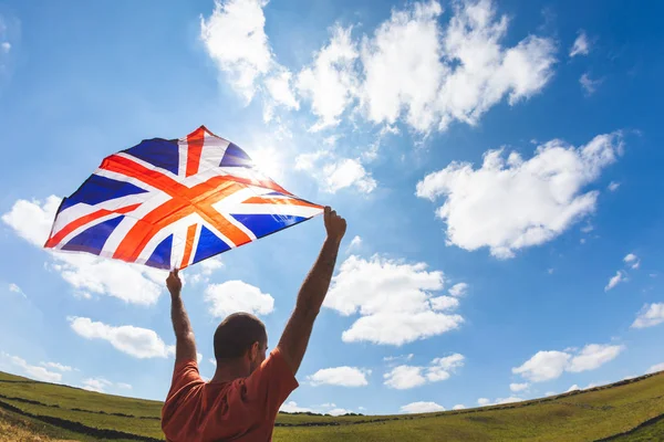 Man Flying UK vlag op het platteland — Stockfoto