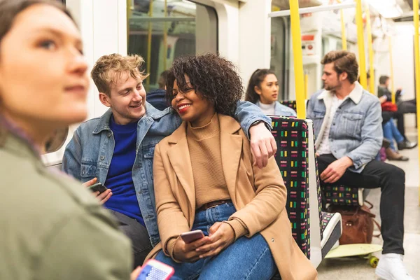 Мультирасовая пара, путешествующая по метро вместе — стоковое фото