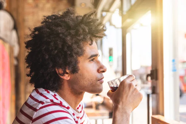 Thoughtful mixed race man drinking soda at cafe bar — Stock Photo, Image
