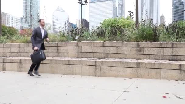 Hombre de negocios corriendo en el centro de Chicago, mirando su reloj — Vídeo de stock