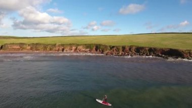 Adam spor yapıyor, kürek çekiyor, deniz kenarında, hava manzaralı.