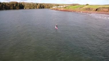 Adam spor yapıyor, kürek çekiyor, deniz kenarında, hava manzaralı.