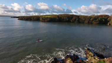 Adam spor yapıyor, kürek çekiyor, deniz kenarında, hava manzaralı.