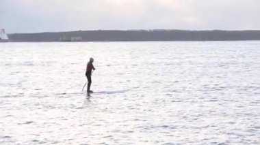 Adam spor yapıyor, kürek çekiyor, deniz kenarında, hava manzaralı.