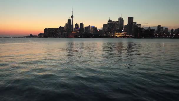 Toronto skyline uitzicht bij zonsondergang aan de overkant van Lake Ontario — Stockvideo