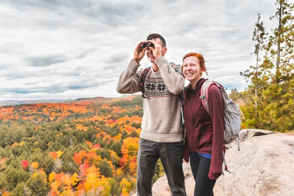 Casal olhando para o panorama com um binocular do topo do — Fotografia de Stock