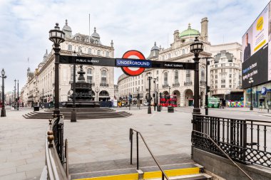 LONDON, UNITED KINGDOM - April 27, 2020: Empty Piccadilly Circus during coronavirus lockdown. Underground entrance in foreground, red bus on background. clipart