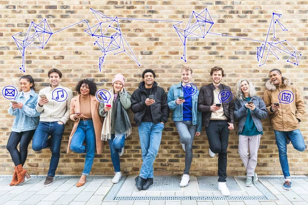 Millennial group of friends using smartphones, icons popping out from screens and links above - Group of young adult with phones and glowing icons of email, music, calendar, phone etc - Technology and lifestyle concepts