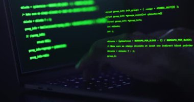 Hacker elleri klavyeye yazı yazıyor, görüntüyü kapatıyor- İnsan kodlaması üzerinde anlamsız kod metni olan bir dizüstü bilgisayar kullanıyor - IT ve teknoloji kavramları