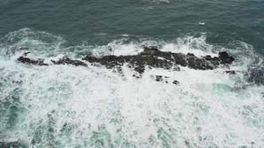 Aerial top down view of waves splashing into rocks in the sea, super slow motion - Travel and nature concepts, background ready HD video