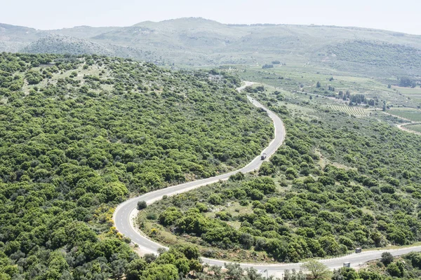 イスラエルのゴランの巻きアスファルト道 ハーモン山の斜面にシリアとの国境近くの風景 — ストック写真