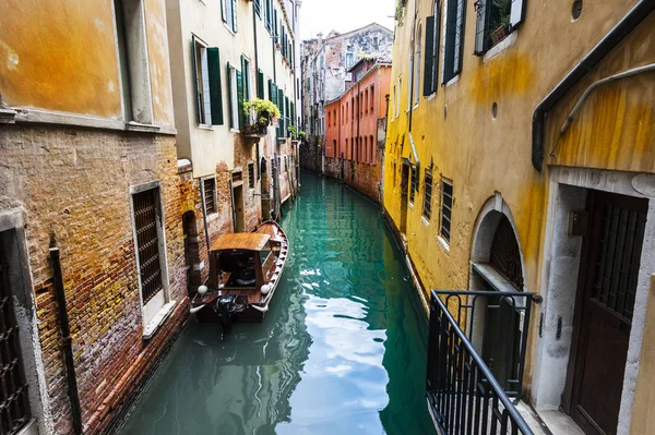 从湿剥落了的房子 威尼斯被位于整个一群岛屿已分离的运河和联系的桥梁 吊船是个传统的 平底的威尼斯人划艇 — 图库照片