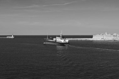 Kargo gemisi Valletta Limanı kalkıyor. Fenerler Malta limanlarına giriş gösterir. Siyah beyaz resim