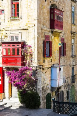 Kişilik geleneksel renkli Malta Valletta tarihi bölümünde bina. Kırmızı windows decoreted bir evde Malta cephesinde begonville ile