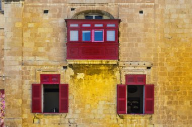 Kişilik geleneksel renkli Malta Valletta tarihi bölümünde bina. Malta bir evde cephesinde üç kırmızı windows