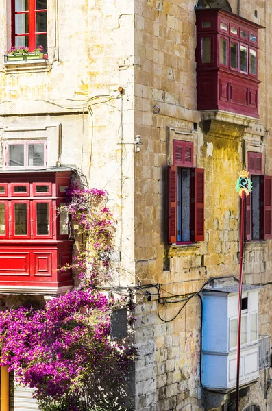 Kişilik geleneksel renkli Malta Valletta tarihi bölümünde bina. Kırmızı windows decoreted bir evde Malta cephesinde begonville ile