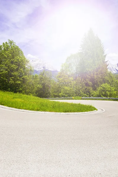 Sabah sis İtalyan Alpleri'nde asfalt yol üzerinde. Görünüm gündoğumu, karayolu ile dağ Vadisi