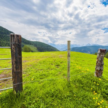 Mera karla kaplı tepeler arka plan üzerinde Avusturya Alpleri'nde dikenli tel çit.