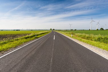 Asfalt yol alanları, otlaklar, çayırlar ve modern rüzgâr türbinleri enerji üreten Avusturyalı peyzaj