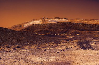Gün batımında İsrail 'deki Negev Çölü' nün Rocky tepeleri. Güney İsrail 'deki kaya oluşumlarının nefes kesici manzarası. Tozlu dağlar wadiler ve derin kraterler tarafından kesildi..