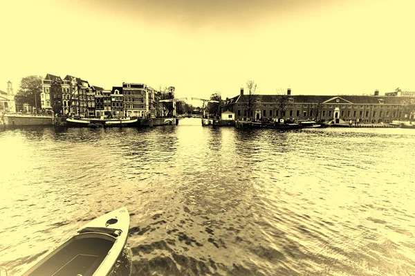 歴史的な市内中心部のアムステルダムの運河のボートします 水上バスながら閉じた状態でアムステルダムの跳ね橋は それに近づいています トーンのビンテージ スタイルの画像 — ストック写真