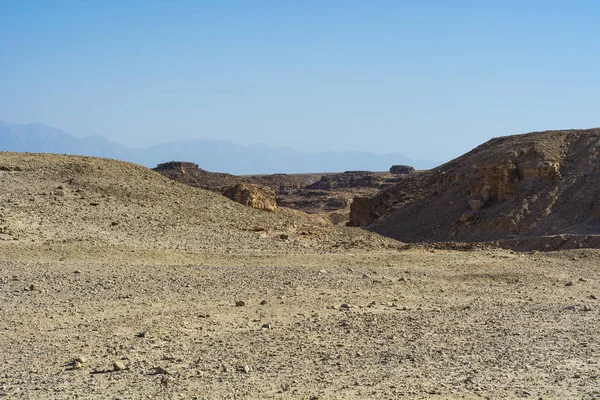 İsrail 'deki Negev Çölü' nün Rocky tepeleri. Güney İsrail 'deki kaya oluşumlarının nefes kesici manzarası. Tozlu dağlar wadiler ve derin kraterler tarafından kesildi..
