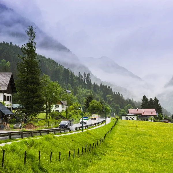 フィールド 牧草地 牧草地や村とオーストリアの風景の中に道路上の朝の霧 オーストリアの農村部の雨アスファルトからぬれた — ストック写真