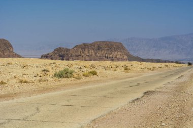 Hiçbir yerde düşük çölde kayalık tepeler arasındaki asfalt yol Güney İsrail kaya oluşumları hiçbir yerde nefes kesici manzara için. Wadis ve derin krater tarafından kesintiye tozlu dağlar.