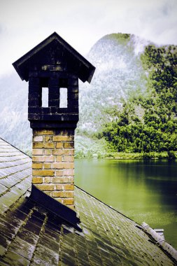  Avusturya Hallstattersee 'de yağmur ve bulutlar. Avusturya 'nın gölü, ormanları, tarlaları, otlakları, çayırları ve ıslak çatıları olan sabah sisi. Retro biçimi