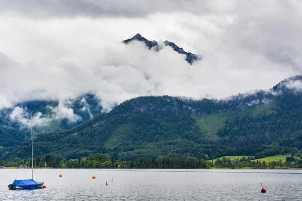 オーストリアのWolfgangseeで雨と雲 ヨット 牧草地 牧草地や村とオーストリアの風景の上の朝の霧 — ストック写真