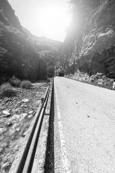 イタリア アルプスのアスファルト道路の上の朝の霧 高速道路と日の出ストリーム山渓谷の眺め 黒と白の写真 — ストック写真