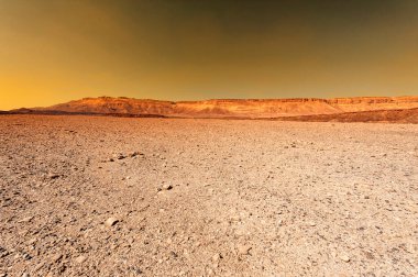 Gün batımında İsrail 'deki Negev Çölü' nün Rocky tepeleri. Güney İsrail 'deki kaya oluşumlarının nefes kesici manzarası. Tozlu dağlar wadiler ve derin kraterler tarafından kesildi..