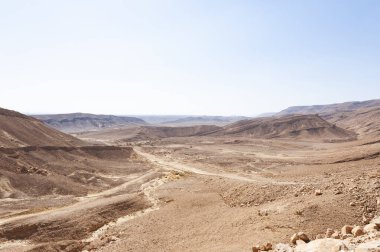 İsrail çölündeki kaya oluşumlarının nefes kesici manzarası. Tozlu dağlar wadiler ve derin kraterler tarafından kesildi..