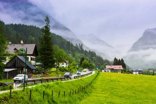 フィールド 牧草地 牧草地や村とオーストリアの風景の中に道路上の朝の霧 オーストリアの農村部の雨アスファルトからぬれた — ストック写真