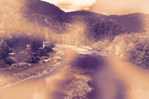 Deserted landscape in France in a contemporary style. Lack of tourists on the banks of a mountain river in the French Alps.