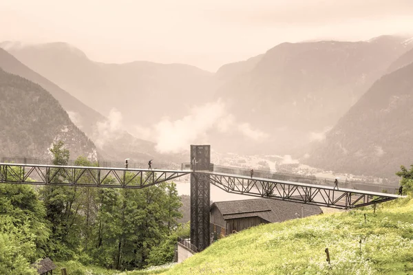 牧草地 牧草地や村とオーストリアの風景の上に朝の霧 雨や雲 歩道橋を通ってオーストリアの湖ハルスタテンゼーの景色 ヴィンテージスタイル — ストック写真