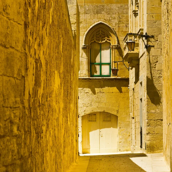Mdina 'nın tarihi bölgesinde geleneksel Malta binaları olan dar bir sokak. Şehir MÖ 8. yüzyılda Malta adasındaki Fenikeli yerleşimciler tarafından Maleth olarak kurulmuştur.