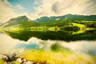 Alpler 'in arka planında Grünlsee Gölü' nü çevreleyen ormanlar, çayırlar, tarlalar ve otlaklar yer alıyor. Klasik stil 