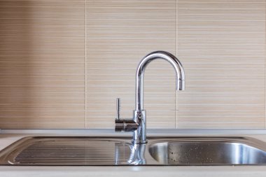 Modern musluğu kapat ve mutfaktaki seramik lavaboyu kapat.