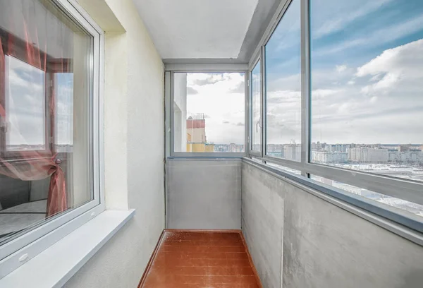 Small old common open balcony interior in high residential apartment building maid of cement