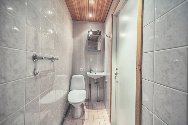 鏡とトイレブラシ付きのモダンなバスルームで白い取り付けられたトイレボウル — ストック写真