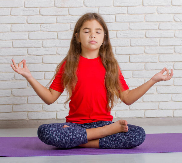Маленькая девочка занимается йогой
