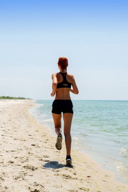 kız deniz kenarında koşuyor