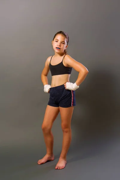 보호용 붕대로 스포츠 반바지를 소녀가 어두운 배경에서 무술을 — 스톡 사진