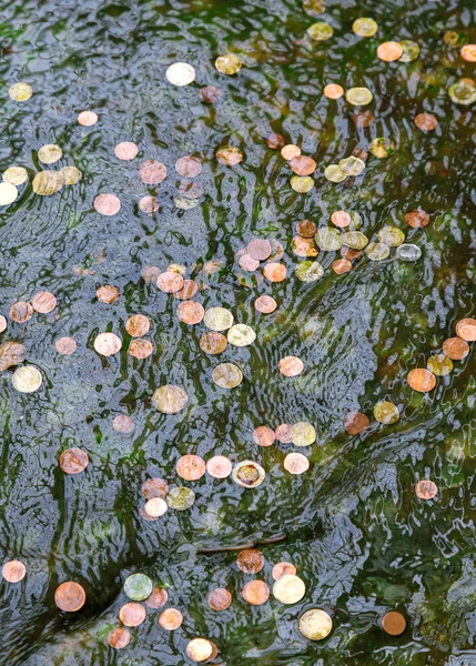 Monedas en el agua de la fuente — Foto de Stock