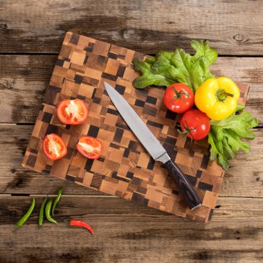 Tahta kesme tahtasındaki bıçak ve sebzeler