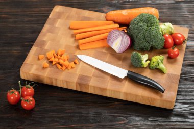 Tahta kesme tahtasındaki bıçak ve sebzeler