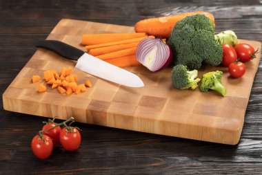 Tahta kesme tahtasındaki bıçak ve sebzeler